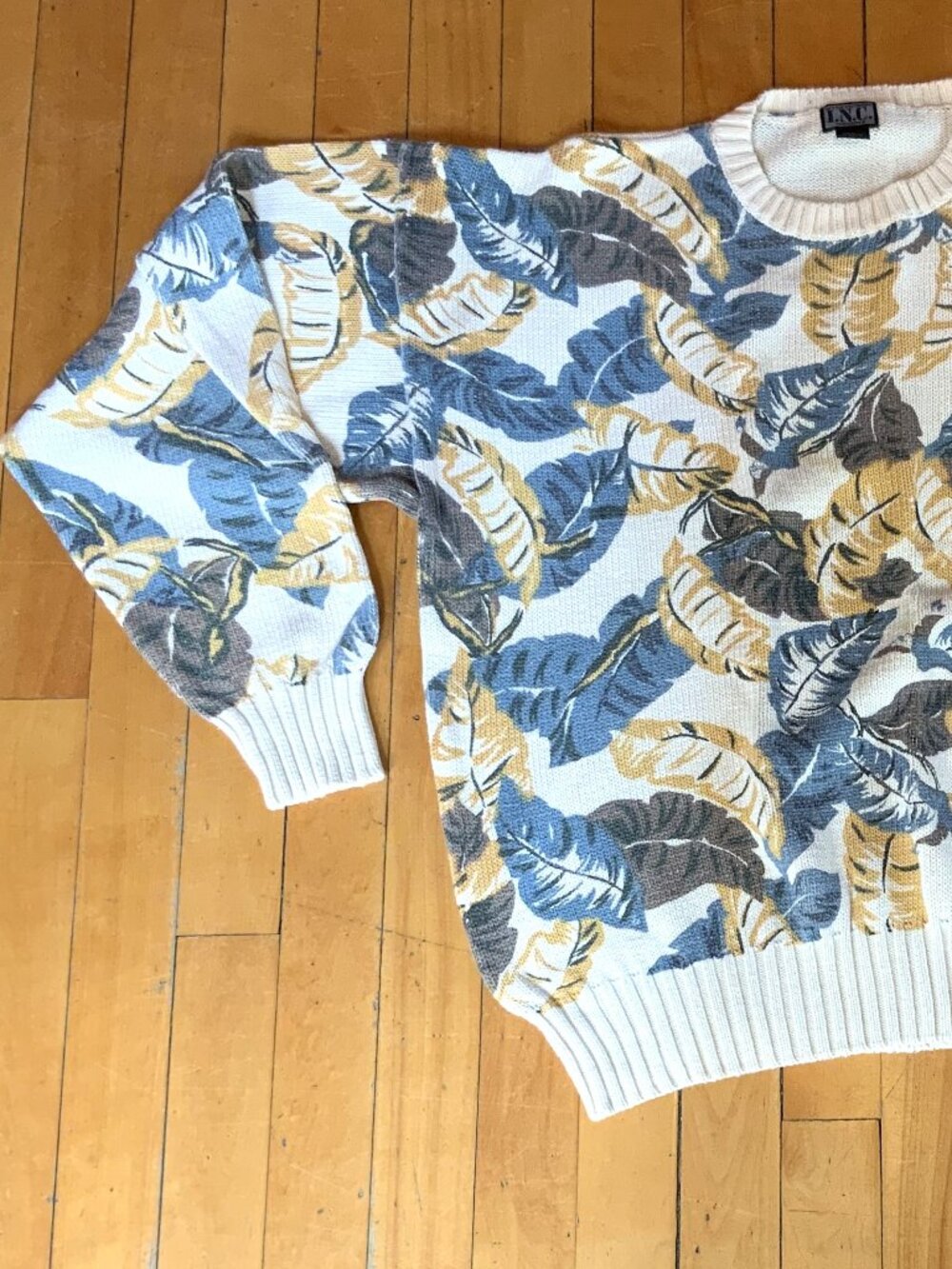 This vintage, cream-colored crewneck sweater features a bold, textured all-over